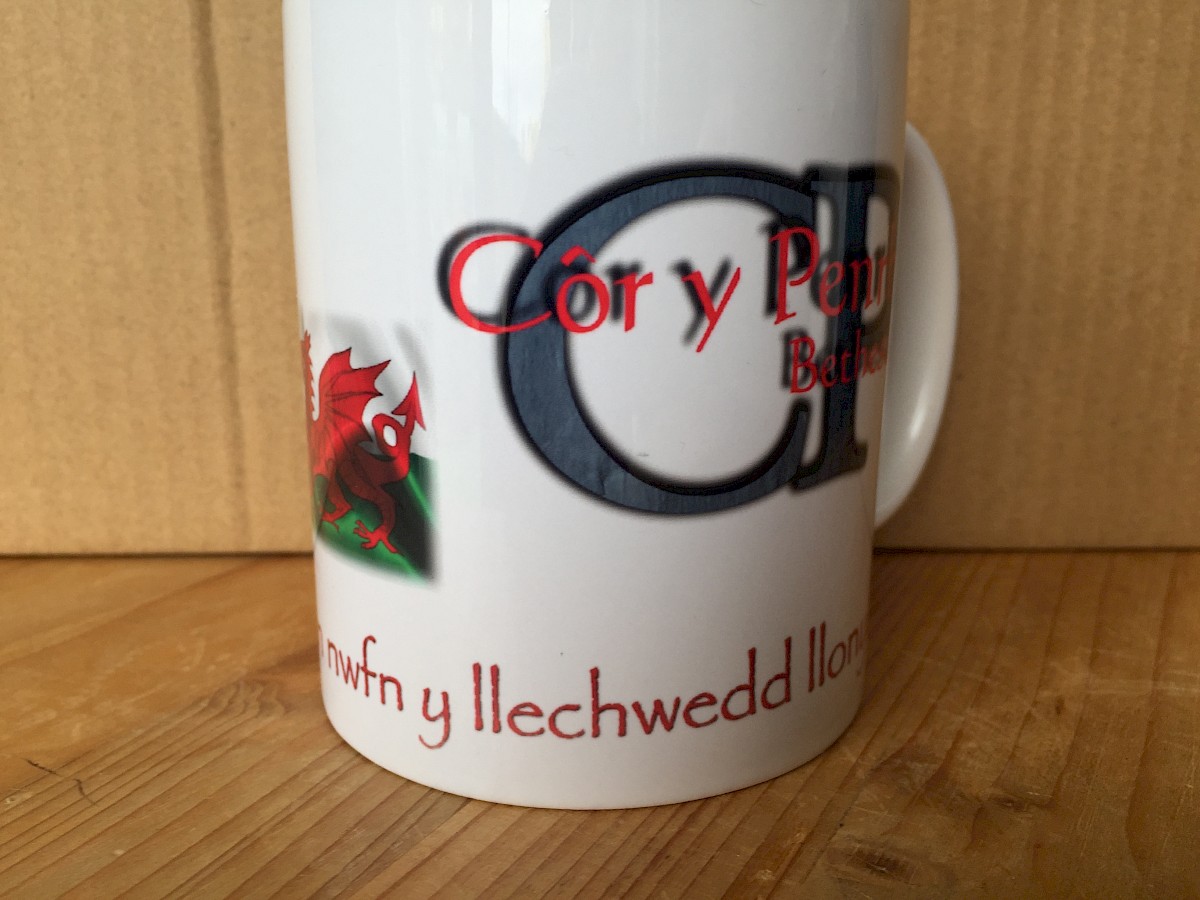 Mwg gyda ysgrifen: Fel gwreiddiau byw
